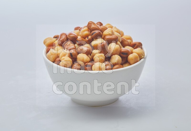 Close up shot of cooked fava beans (foul) & chickpeas on white background