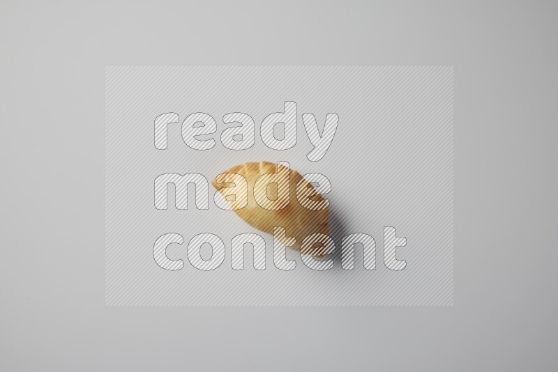 One fried sambosa from a top angle on a white background