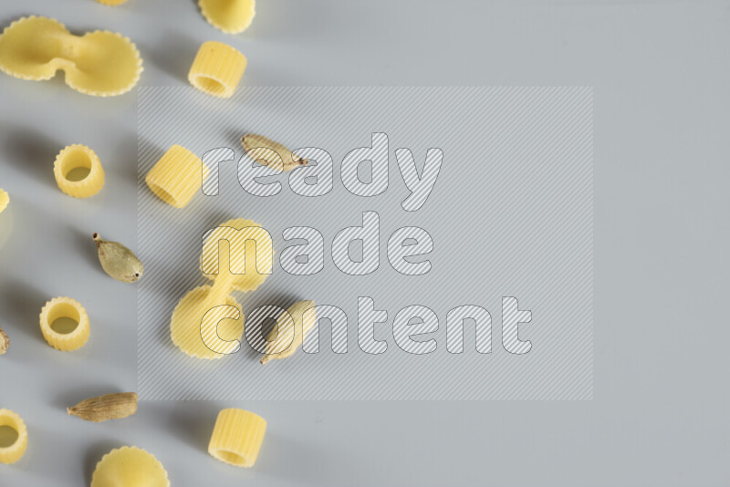 معكرونة مع مكونات متنوعة من الطماطم والثوم والبصل والفلفل الأحمر والفلفل الأسود والفلفل الأبيض وأوراق الغار وإكليل الجبل والهيل و مشروم على خلفية زرقاء فاتحة