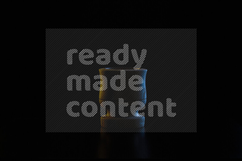 Wooden kitchen essentials with colored rim light against black background