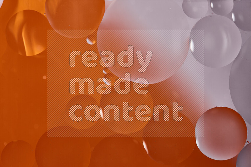 Close-ups of abstract oil bubbles on water surface in shades of white and orange
