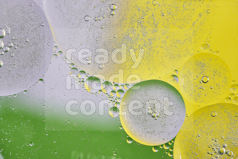 Close-ups of abstract oil bubbles on water surface in shades of yellow, green and white
