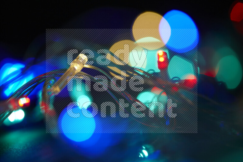 Light bulbs glowing against backdrop of multicolord bokeh