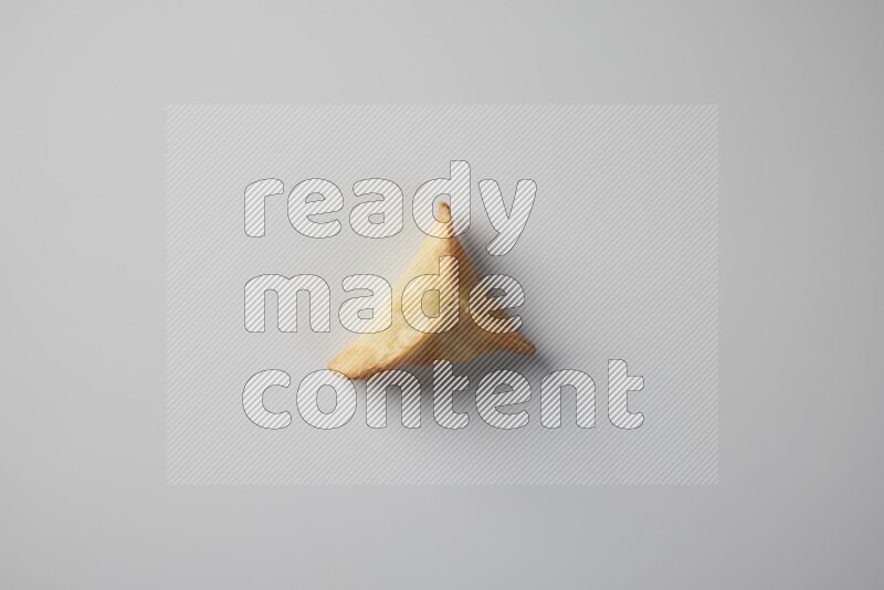 One fried sambosa from a top angle on a white background
