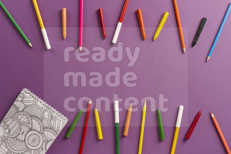 A coloring book with coloring pens on purple background