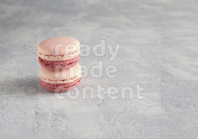 45º Shot of two Pink Litchi Raspberry macarons  on white  marble background