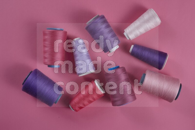 A purple and pink collection of sewing and tailoring tools arranged on a pink background