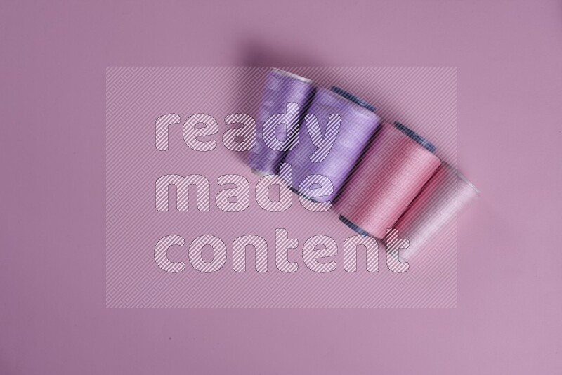 A purple and pink collection of sewing and tailoring tools arranged on a pink background