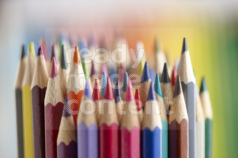 The image captures a close-up of sharpened colored pencils on multicolored background
