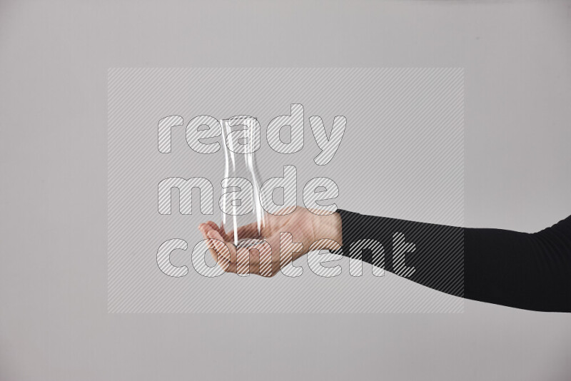 A woman in black abaya holding different glassware in different positions