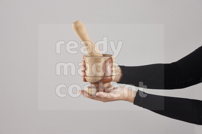 A woman in black abaya holding different wooden essentials in different positions