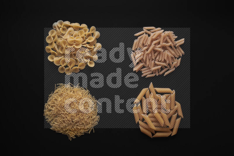 Different pasta types in bunches on black background