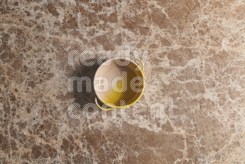 A multicolored pottery bowl on beige marble background