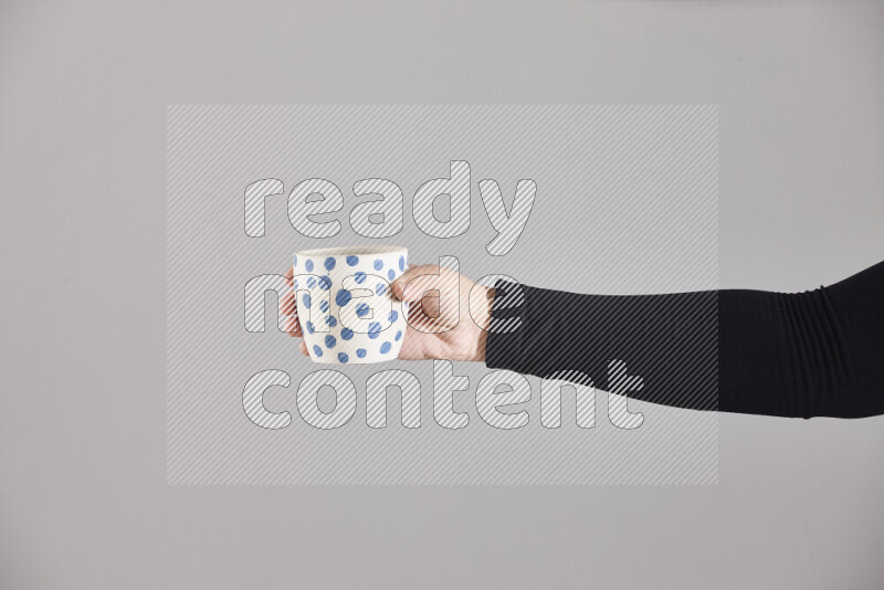 A woman in black abaya holding different pottery essentials in different positions