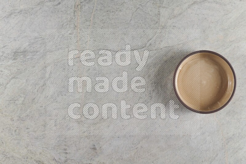 وعاء فرن فخاري باللون البيج على خلفية من الرخام الرمادي