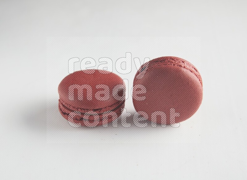 45º Shot of two Red Velvet macarons on white background