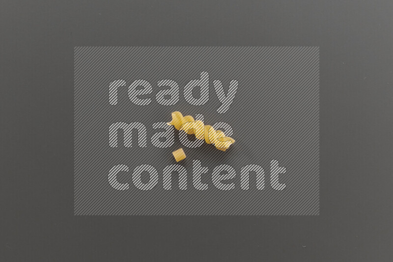Small rings pasta with other types of pasta on grey background
