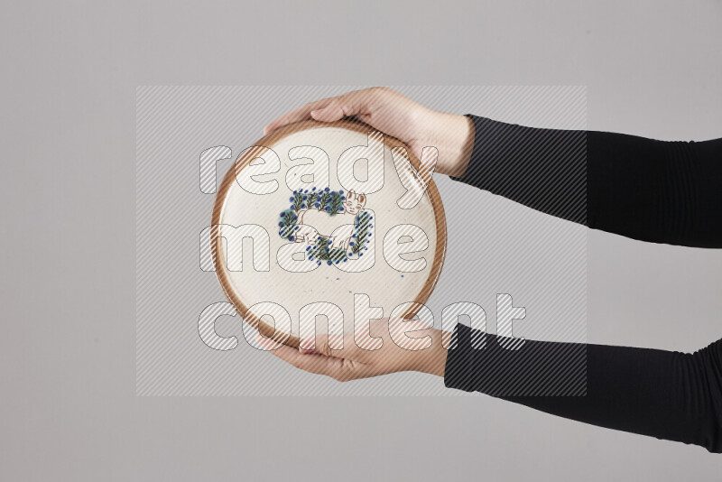 A woman in black abaya holding different pottery essentials in different positions