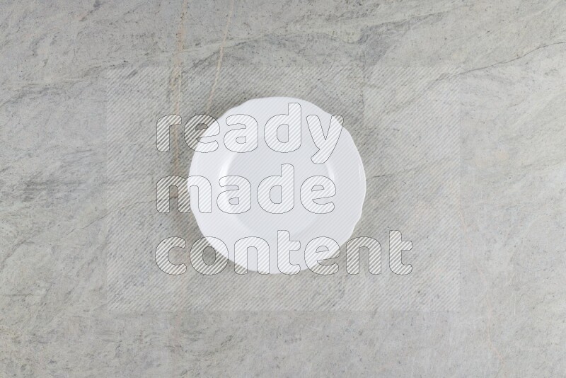 A white ceramic circular plate on grey marble background