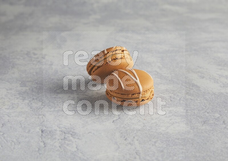 45º Shot of two Brown Irish Cream macarons  on white  marble background