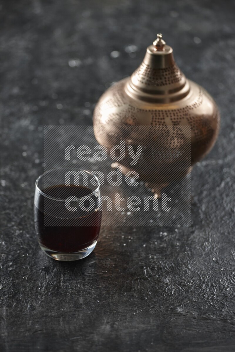A golden lantern with different drinks, dates, nuts, prayer beads and quran on textured black background