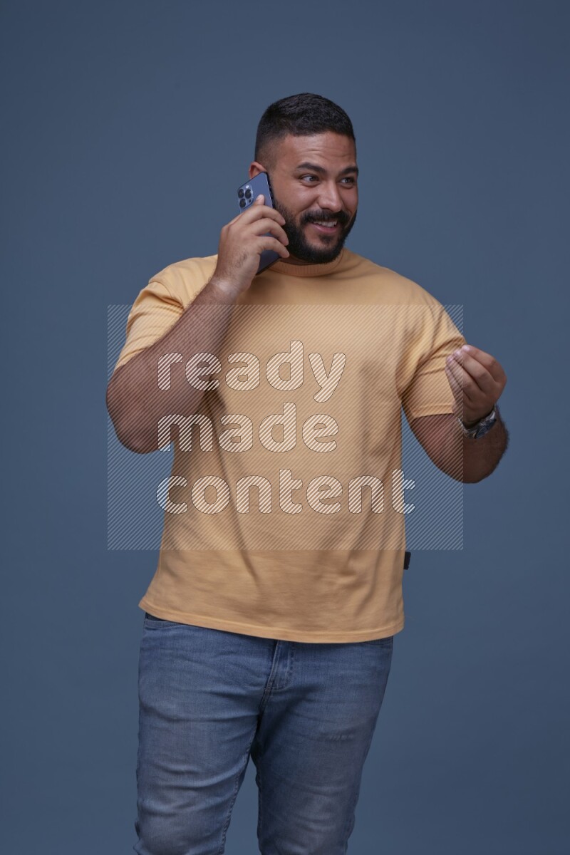 A man Calling on Blue Background wearing Orange T-shirt