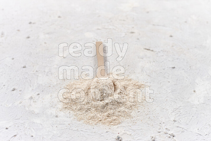 A wooden spoon full of onion powder on white background