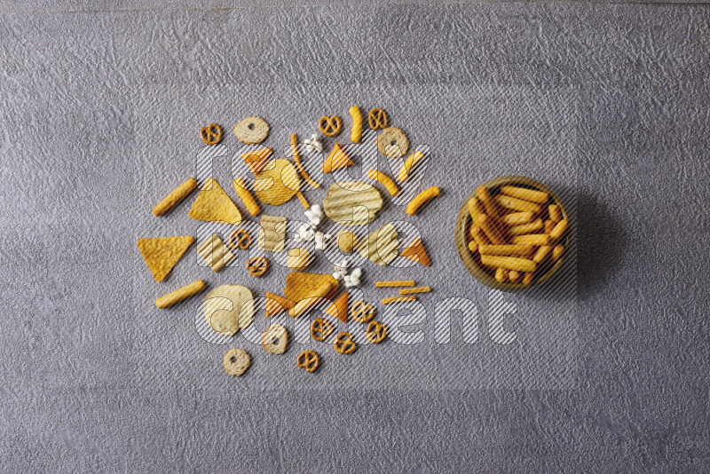 Assorted snacks in pottery bowls on grey background