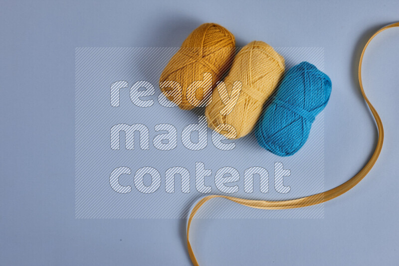 مجموعة من أدوات الخياطة والتفصيل صفراء وزرقاء اللون على خلفية زرقاء