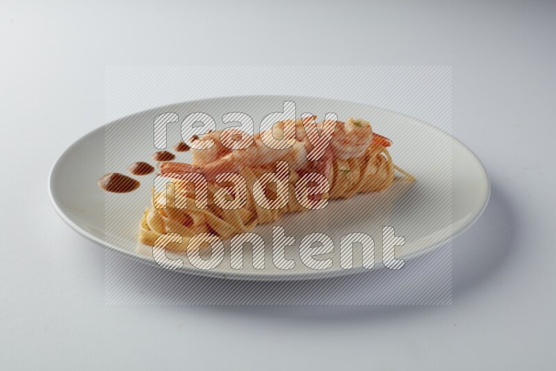 Fettuccini red sauce pasta with shrimp in a white plate on a white background