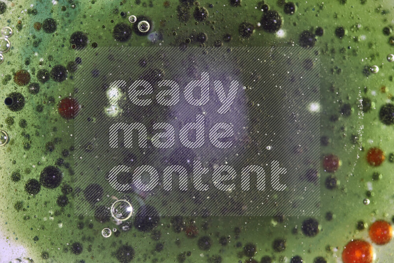 Close-ups of abstract red, green and blue watercolor drops on oil Surface on green background