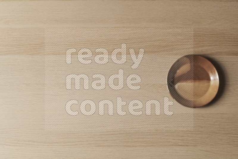 A multicolored pottery plate on light wooden background