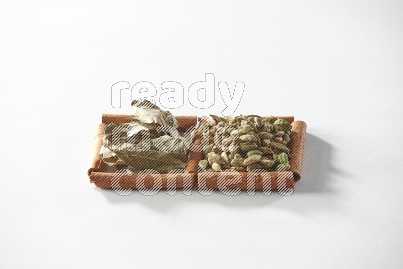 2 squares of cinnamon sticks full of cardamom and bay laurel leaves on white flooring