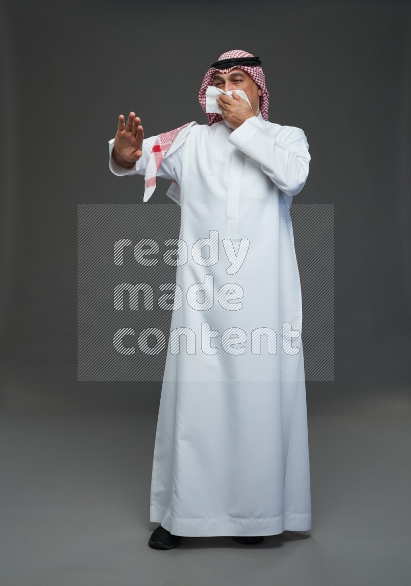 Saudi man with shomag Standing feeling sick on gray background