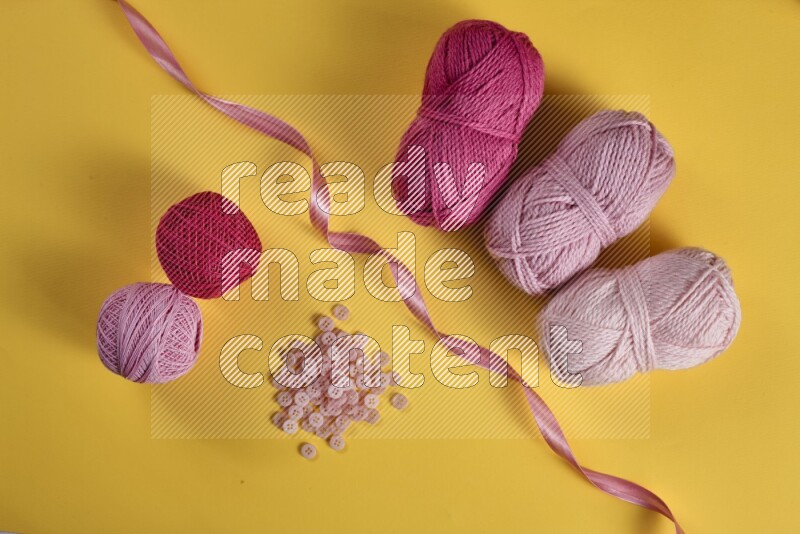 مجموعة من أدوات الخياطة والتفصيل زهرية اللون على خلفية صفراء