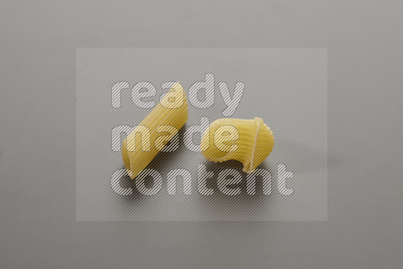 Penne pasta with other types of pasta on grey background