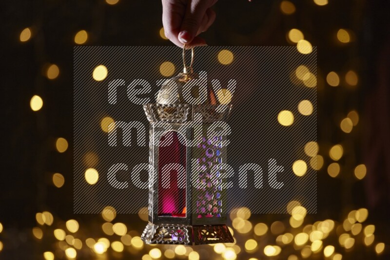 A traditional ramadan lantern surrounded by glowing fairy lights in a dark setup