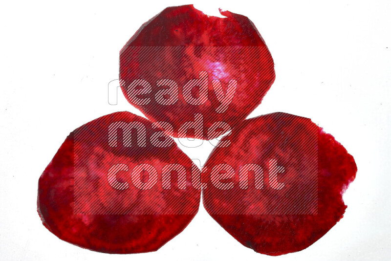 Beet slices on illuminated white background