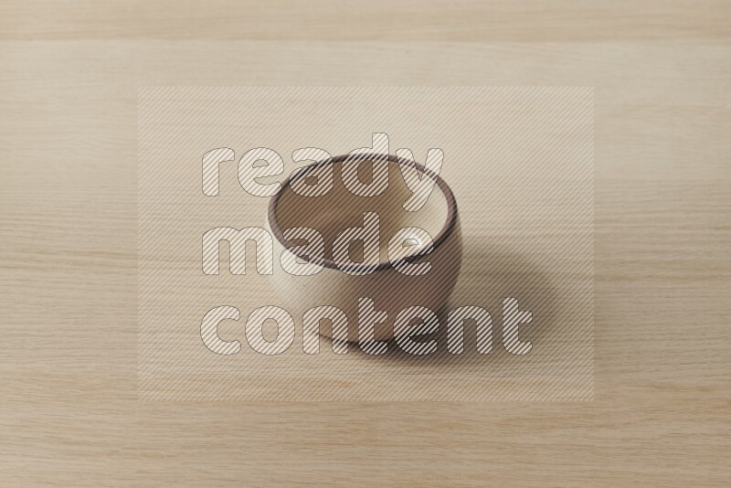 وعاء فرن فخاري باللون البيج على خلفية خشبية فاتحة