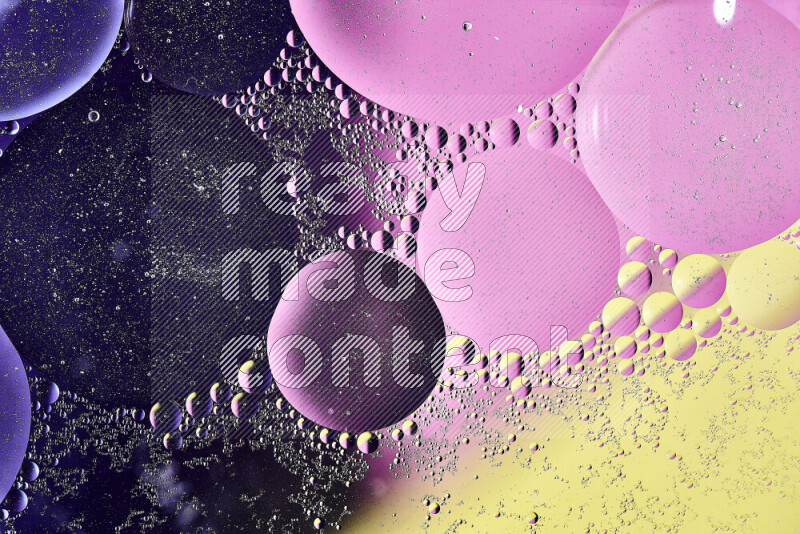 Close-ups of abstract oil bubbles on water surface in shades of yellow, purple and pink