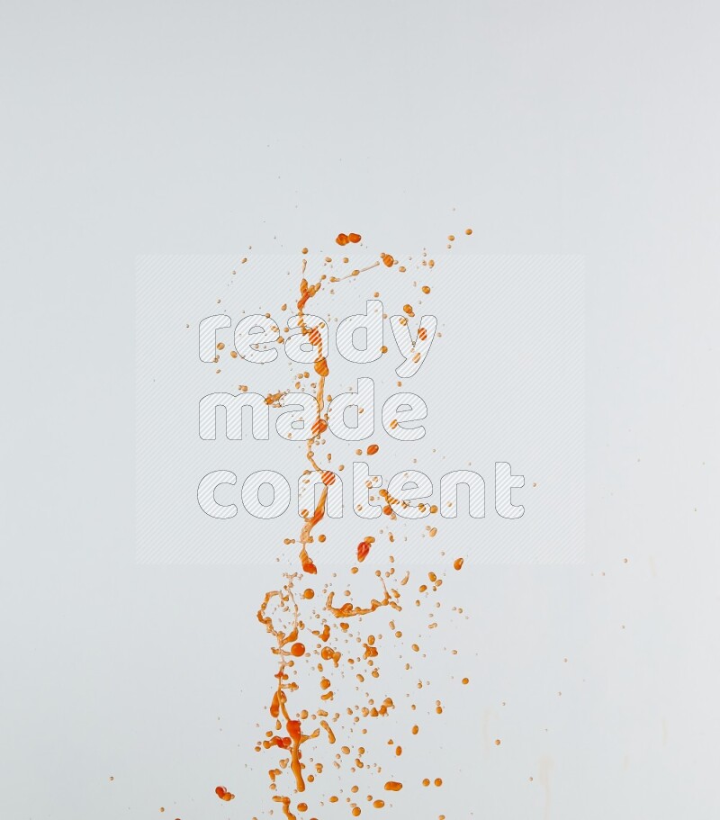 Orange liquid splash and drops on white background