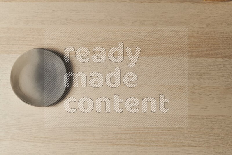 صحن فخاري متعدد الألوان على خلفية خشبية فاتحة