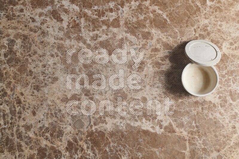 A pottery cup on beige marble background