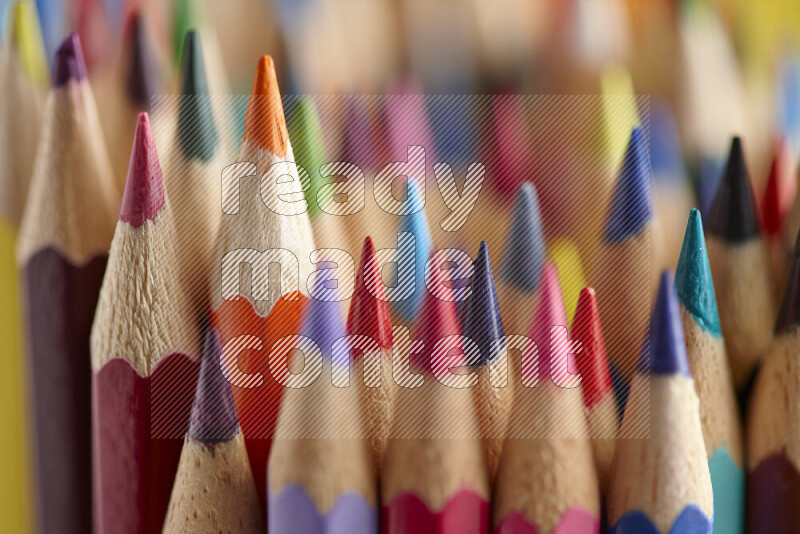 The image captures a close-up of sharpened colored pencils on multicolored background
