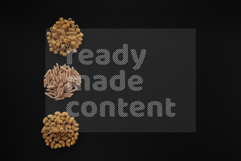 Different pasta types in 3 bunches on black background
