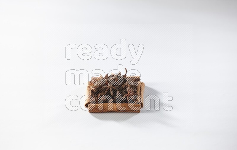 A single square of cinnamon sticks full of star anise on white flooring