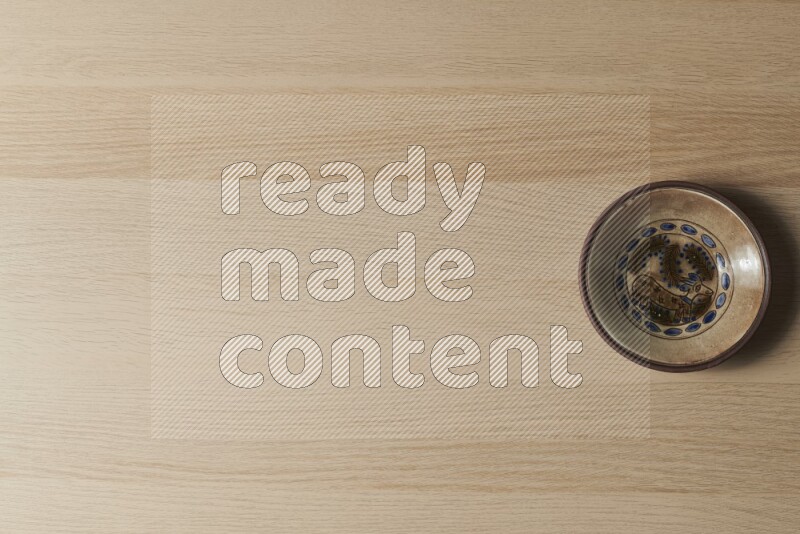 A decorative pottery plate on light wooden background
