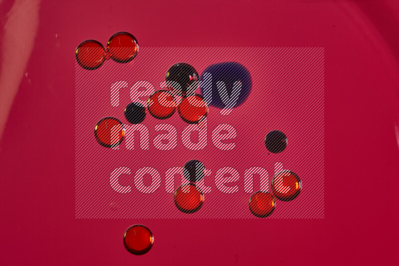 Close-ups of abstract red and blue watercolor drops on oil Surface on red background