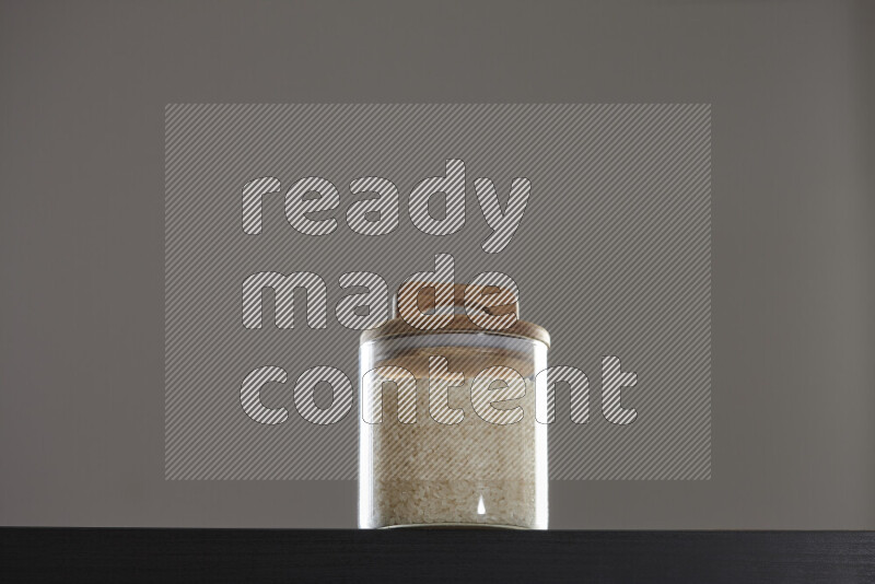 White rice in a glass jar on black background