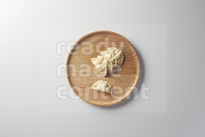 Five Sambosas on a wooden round plate on a white background